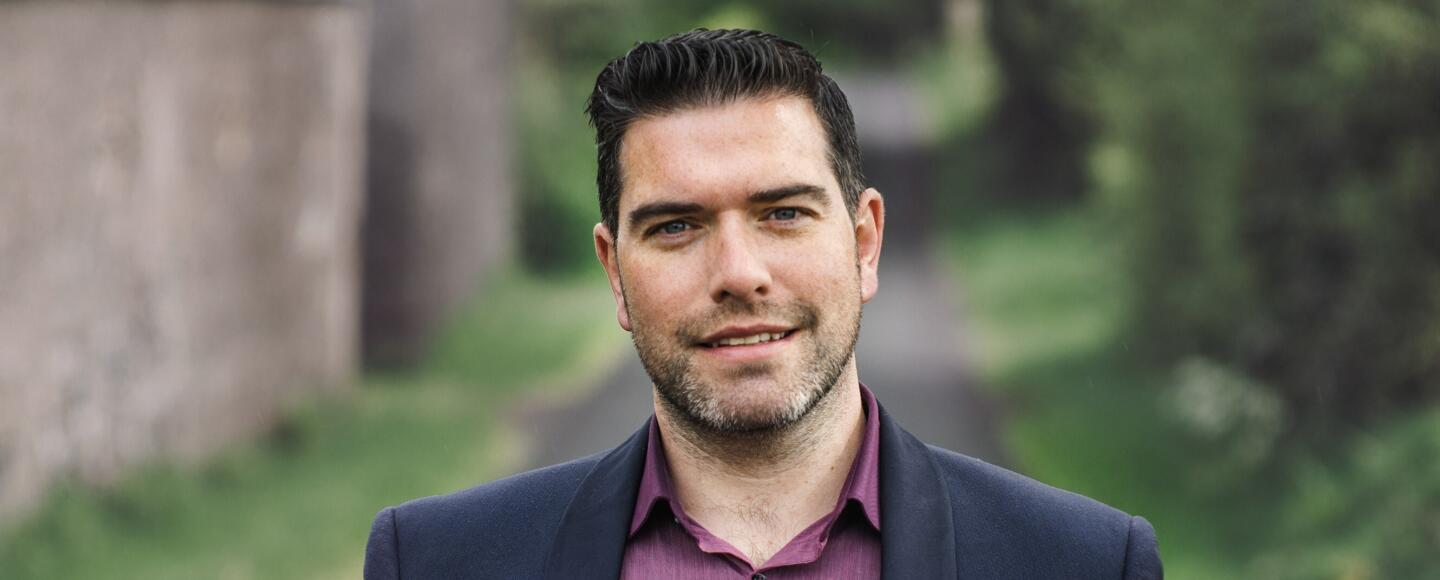 James Bradley standing outdoors wearing a shirt and jacket