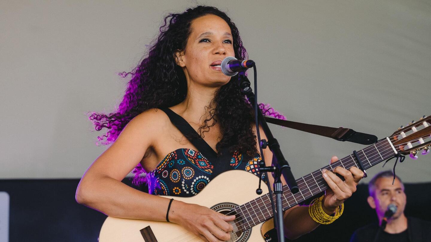 Musician singing into a microphone playing the guitar